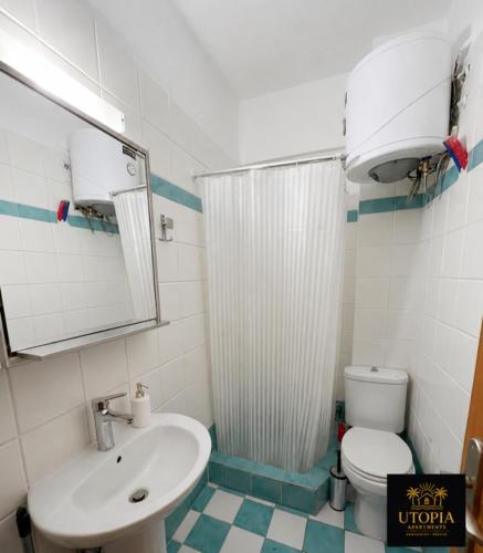 a bathroom with a sink and a shower and a toilet at Utopia Apartment in Kallithea Halkidikis
