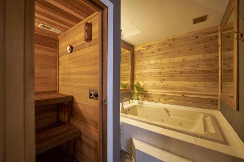 a bathroom with a tub and wooden walls at Trailhead Lodge in Bend