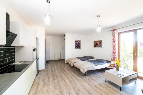 a bedroom with a bed and a living room at Central Apartments Premium in Goleniów