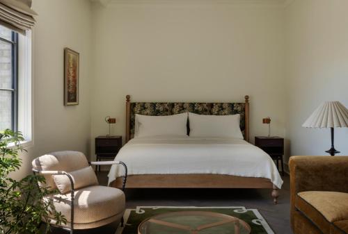 a bedroom with a bed and a chair at The Nickel Hotel in Charleston
