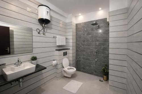 a bathroom with a toilet and a sink and a shower at Hotel LA Costa, A Luxury Hotel In Haridwar in Haridwār