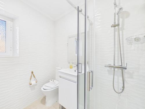 a white bathroom with a shower and a toilet at 2BR Terrace with Tagus View - Air-Conditioned | By Airnest in Lisbon