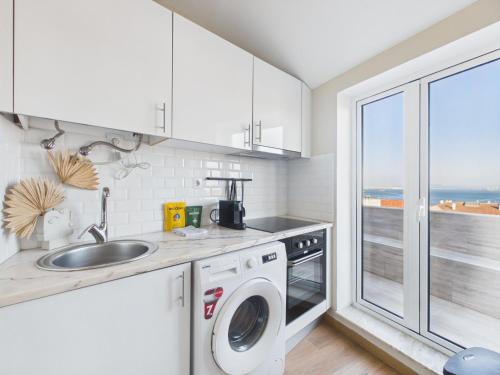 a kitchen with a sink and a washing machine at 2BR Terrace with Tagus View - Air-Conditioned | By Airnest in Lisbon