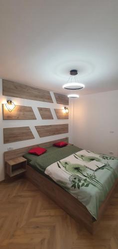 a bedroom with a bed with a wooden wall at ApartHotel NoahResidence in Alba Iulia