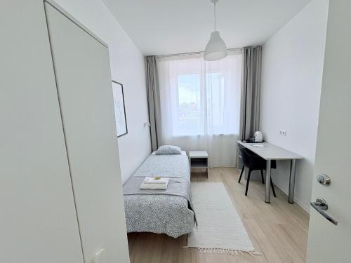 a bedroom with a bed and a desk and a window at Endla Hostel ja Apartamendid in Haapsalu