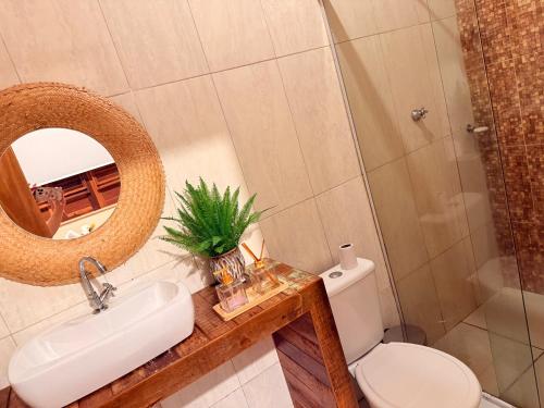 a bathroom with a toilet and a sink and a mirror at Rancho PJ - Presidente Juscelino-MA in Morros