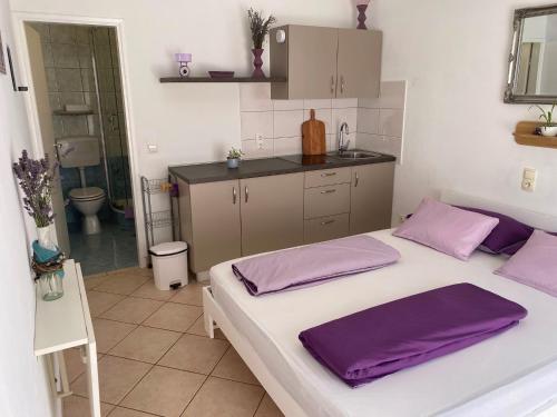a bedroom with a large bed with purple pillows on it at Apartments Natali in Sveti Petar