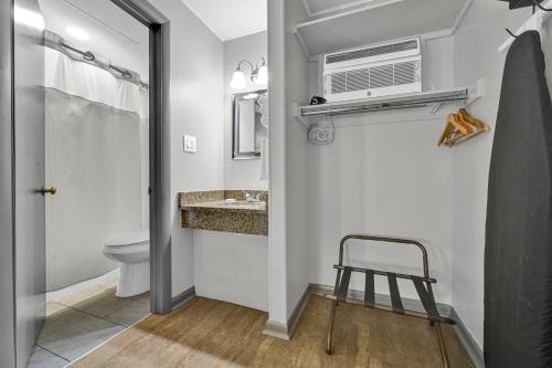 a bathroom with a toilet and a sink and a fan at Harvest Drive Family Inn - Renovated Rooms in Gordonville