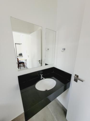 a bathroom with a sink and a mirror at Mimos Hospedagem in São Paulo