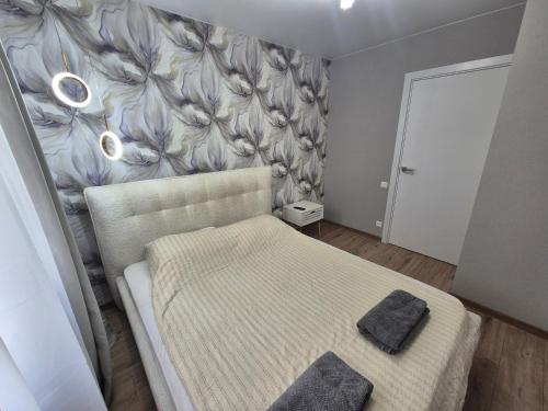 a bedroom with a bed and a wall with flowers at Like home in Narva