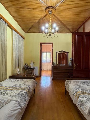 a bedroom with two beds and a chandelier at Dream House in Batumi
