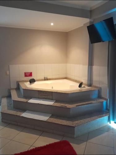 a bath tub in a room with a tv at Florença Hotel in Quedas do Iguacu