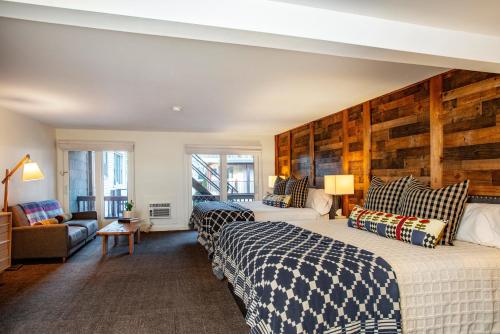 a hotel room with two beds and a couch at The Outpost by Windham Mountain Club in Windham