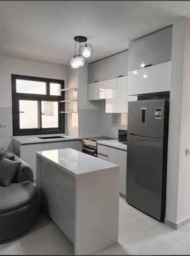 a kitchen with a refrigerator and a table in it at D-bay north coast 4 bed rooms villa minimum stay 3 nights in Zāwiyat ‘Abd al Mun‘im