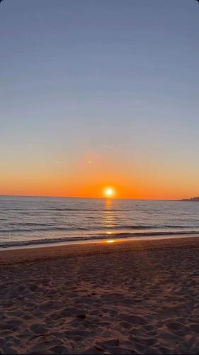 a sunset on the beach with the sun setting at Hotel sefa brothers in Golem