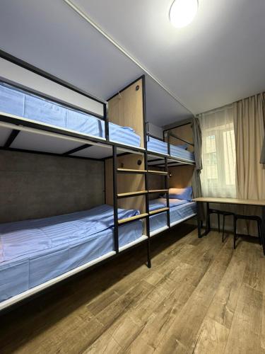 two bunk beds in a room with a wooden floor at Mickey central 2 hostel in Ulaanbaatar