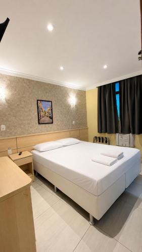 a bedroom with a large white bed in a room at Hotel Villa Rica in Rio de Janeiro
