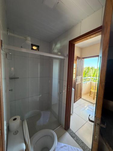 a bathroom with a shower and a toilet at Pousada Caravelas in Guarapari