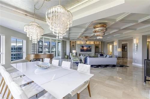 a dining room with a white table and chandeliers at Grande Vista Retreat in Naples