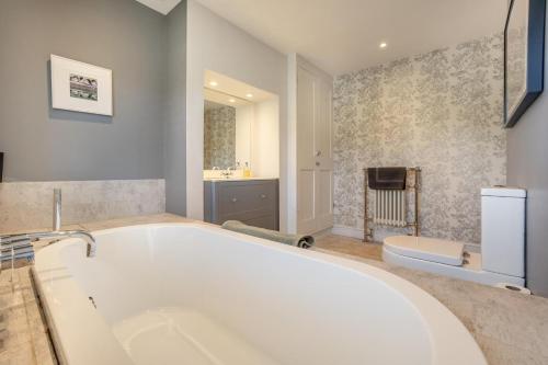 a large white bath tub in a bathroom at 3 Bed in Reydon oc-brae in Reydon