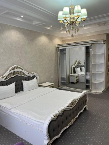 a bedroom with a large bed and a mirror at Suleyman House Premium in Bukhara