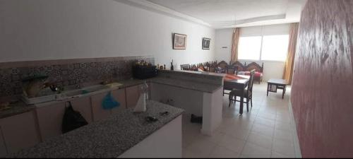 a kitchen with a table and a dining room at Maison front de mer 2 in Kelibia