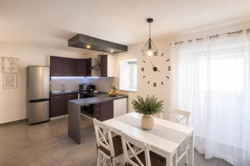 a kitchen with a table and a clock on the wall at App Aurum in Brtonigla