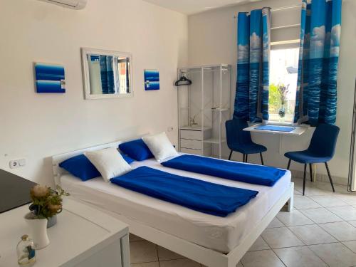 a bedroom with a bed with blue sheets and a desk at Apartments Natali in Sveti Petar