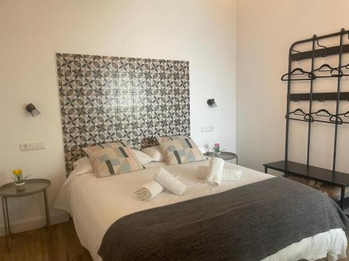 a bedroom with a large bed with white pillows at Patio de Los Barberos in Valle de Abdalagís