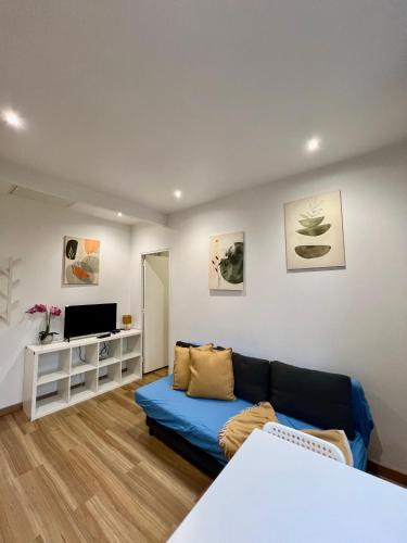 a living room with a blue couch and a tv at Chemin de fer adorable appartement in Gagny