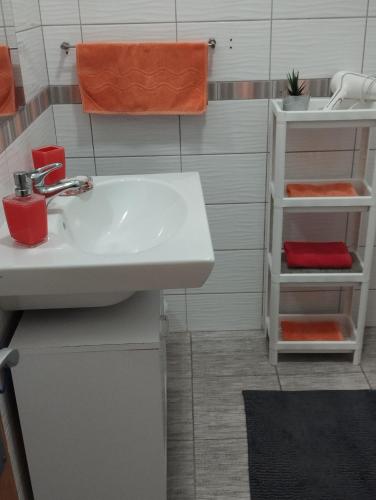 a bathroom with a white sink and an orange towel at Apartmani Zara & Duje in Bibinje