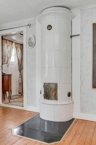 a living room with a fireplace in the middle of a room at Lindgren Land in Vimmerby