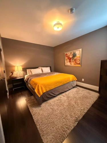 a bedroom with a bed with a yellow bedspread at White Rock Joy Inn in White Rock