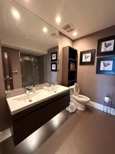 a bathroom with a sink and a toilet and a mirror at White Rock Joy Inn in White Rock