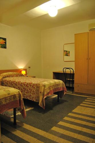 a hotel room with two beds and a cabinet at Hotel Major in Genoa