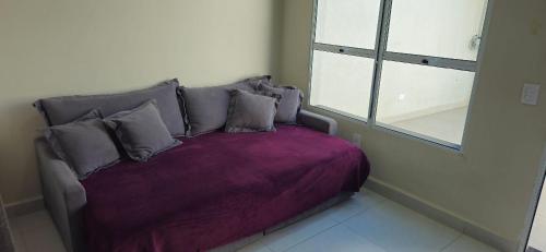 a bed in a room with a purple blanket at Casa 2 Quartos com Ar até 8 Pessoas Jd. Sabiás in Indaiatuba