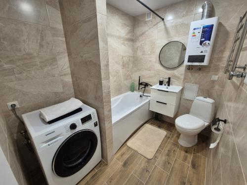 a bathroom with a washing machine and a toilet at Apartments near border in Narva