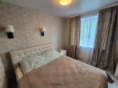 a bedroom with a large bed and a window at Apartments near border in Narva
