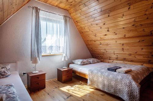 a bedroom with two beds and a window at Domki Oaza Spokoju in Nowęcin