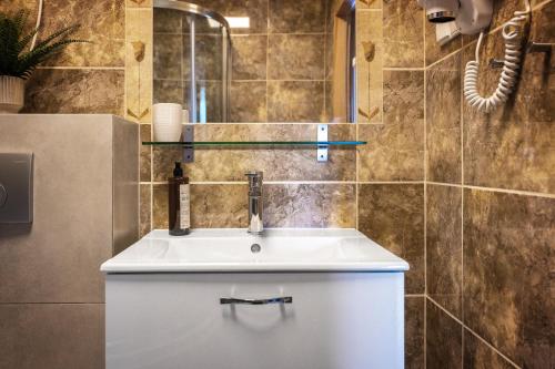 a bathroom with a white sink and a mirror at Domki Oaza Spokoju in Nowęcin