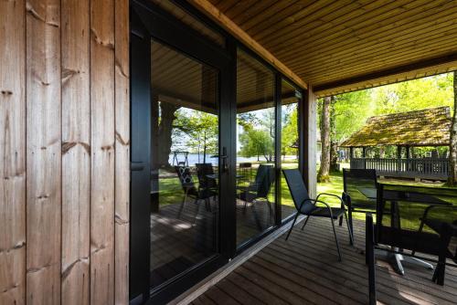 a screened porch with glass doors and a table and chairs at Lukstas Rest Park in Graužai