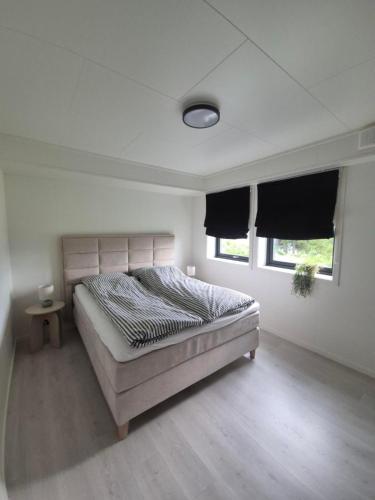 a bedroom with a bed in a room with two windows at Senja Laukhella in Senja