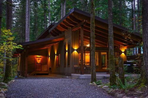 a log cabin in the woods with lights on at Elysian at Mount Baker in Glacier