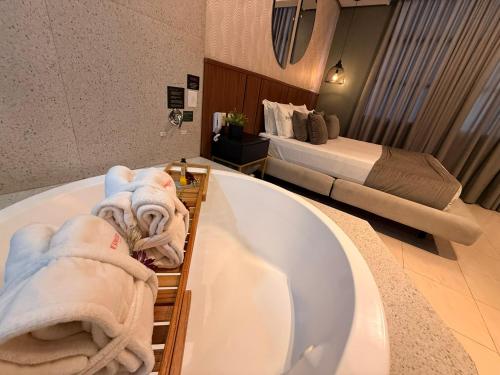 a bathroom with a bath tub and a bed at Hotel Motel Sherwood in Porto Alegre