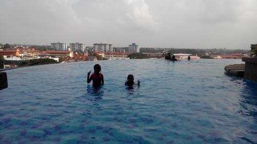 two people in a swimming pool in the water at SAS D'PERDANA Apartment in Kota Bharu