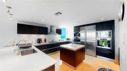 a large kitchen with black and white appliances at Jade Beach Escape in Sunny Isles Beach
