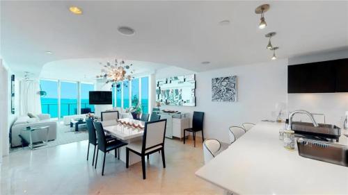 a dining room and living room with a table and chairs at Jade Beach Escape in Sunny Isles Beach