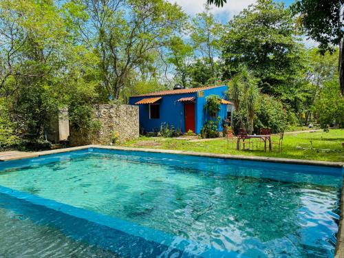 a house with a swimming pool in front of a house at Loft Bugambilia en Casa Viva Merida in Techoh