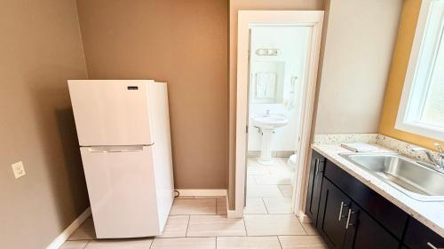 a white refrigerator in a kitchen with a sink at Capitol Hill Motel in Portland