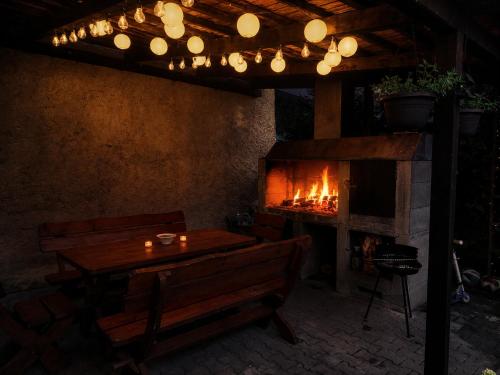 a living room with a fireplace and a table and bench at Chaloupka v srdci památkové zóny in Putím